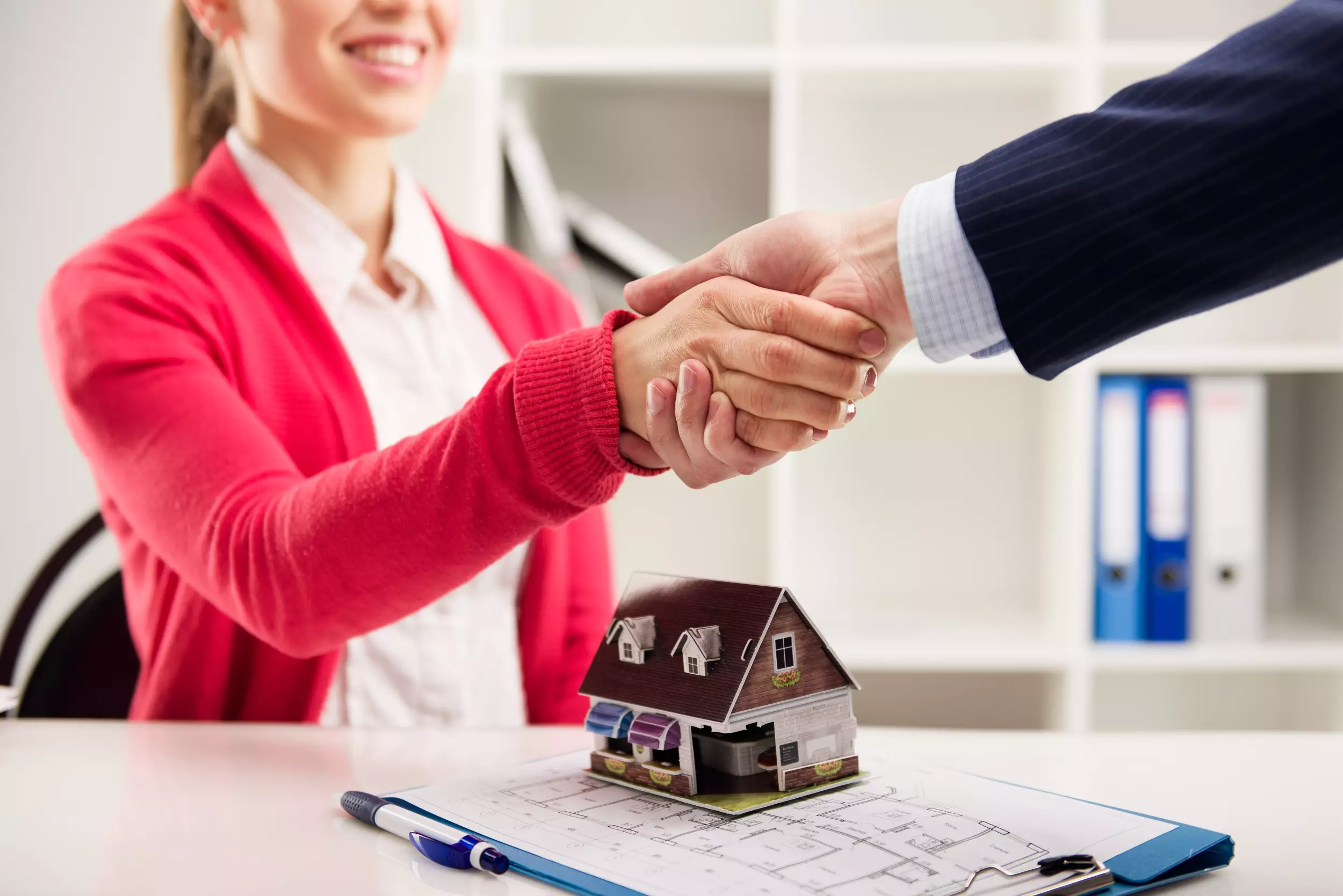 Shaking hands over a model home